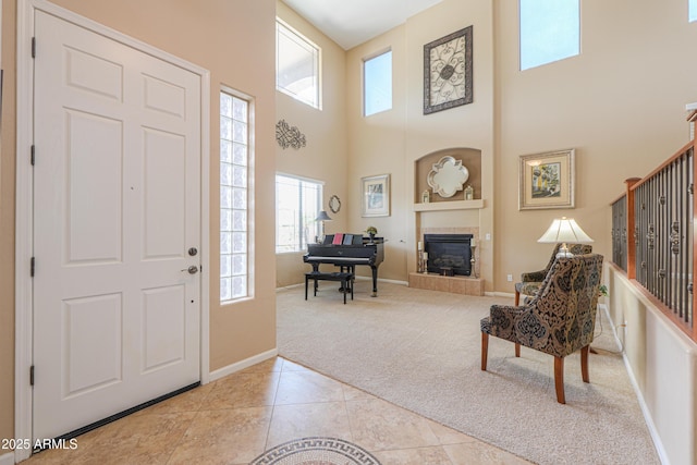21841 N Ingram Ct, Maricopa, AZ 85138 - entryway with light carpet, a towering ceiling, healthy amount of natural light, a fireplace, and light tile patterned flooring