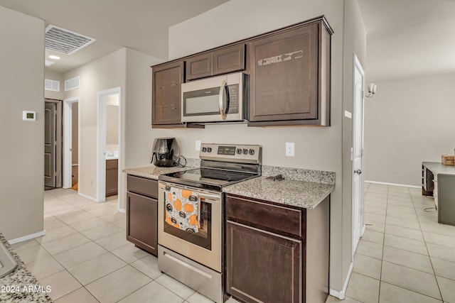 kitchen featuring light tile patterned floors, visible vents, stainless steel appliances, dark brown cabinets, and baseboards