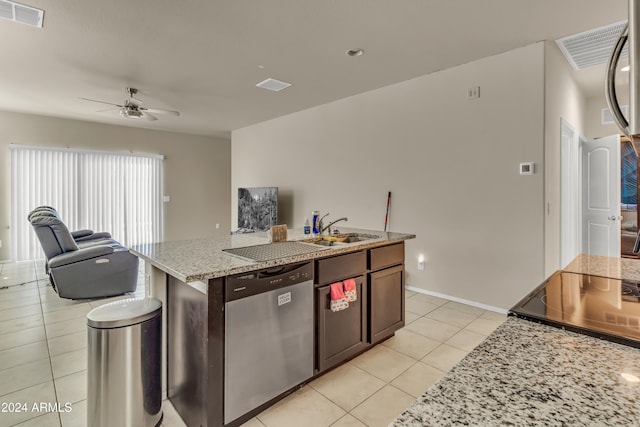 kitchen featuring light stone countertops, stainless steel dishwasher, a center island with sink, light tile patterned floors, and ceiling fan