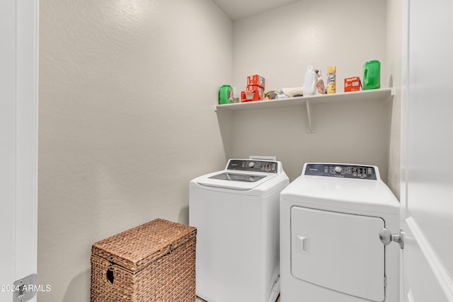 laundry room with separate washer and dryer, a textured wall, and laundry area
