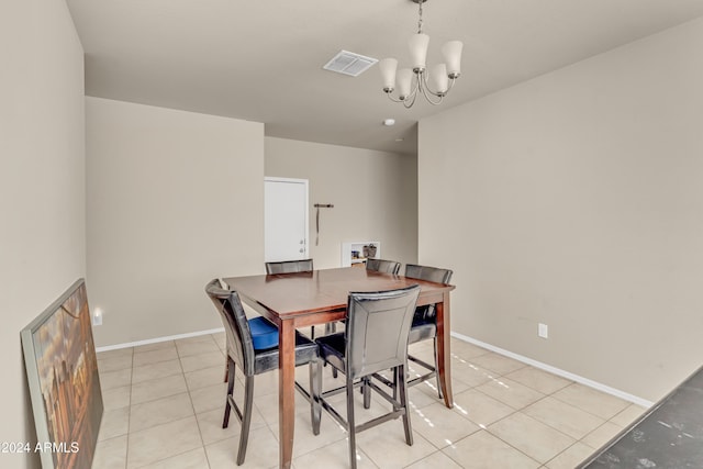 dining area featuring light tile patterned floors, visible vents, a notable chandelier, and baseboards