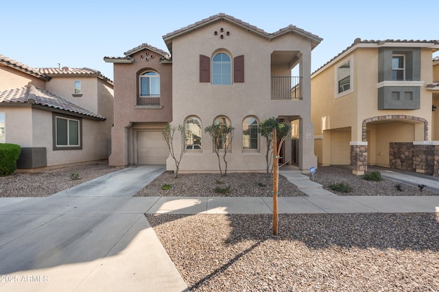 mediterranean / spanish home featuring a balcony, driveway, stucco siding, a garage, and a tiled roof