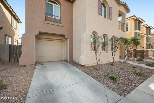 mediterranean / spanish house with stucco siding, driveway, a tile roof, and a garage