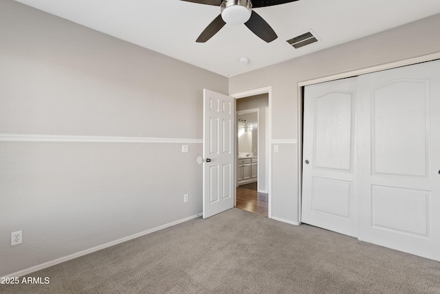 unfurnished bedroom with carpet, a closet, and ceiling fan