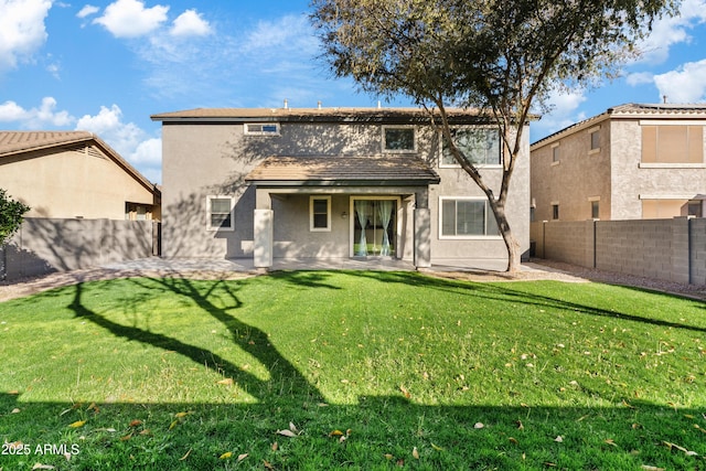 rear view of property featuring a yard and a patio