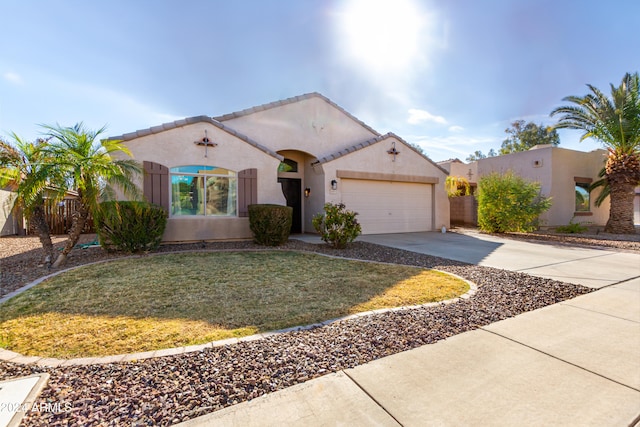 mediterranean / spanish-style home featuring a front yard, concrete driveway, an attached garage, and stucco siding