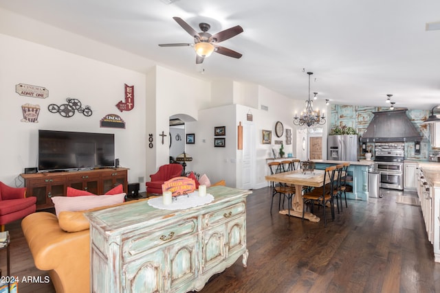 living area with arched walkways, vaulted ceiling, wood finished floors, and ceiling fan with notable chandelier