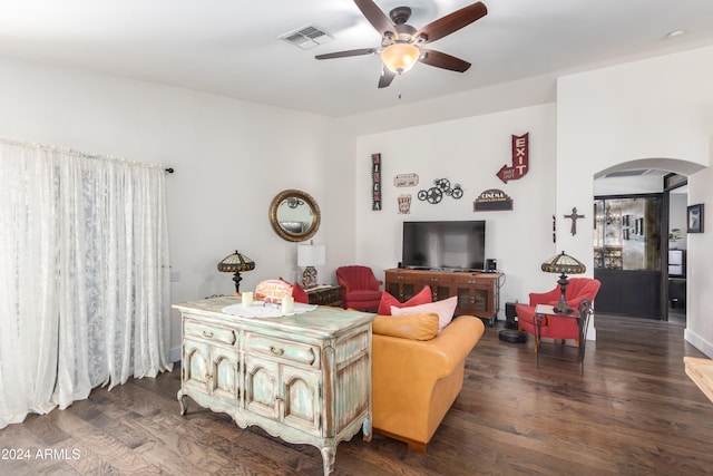 living room featuring arched walkways, visible vents, dark wood finished floors, and ceiling fan