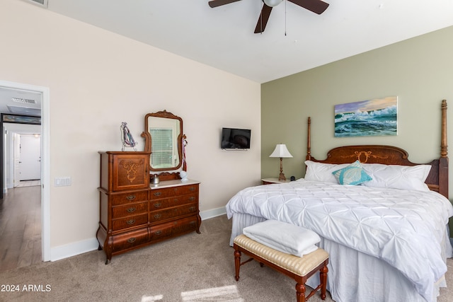 bedroom featuring a ceiling fan, light carpet, visible vents, and baseboards