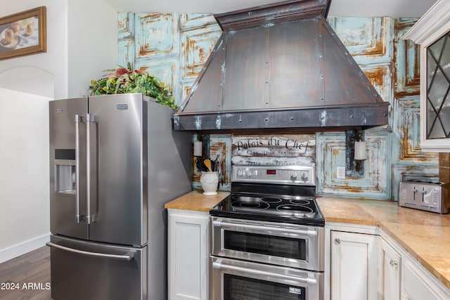 kitchen featuring white cabinetry, appliances with stainless steel finishes, light countertops, and exhaust hood