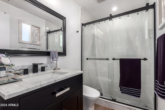 bathroom featuring toilet, vanity, and hardwood / wood-style flooring