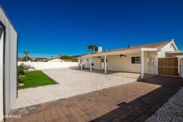 back of property with ceiling fan and a patio