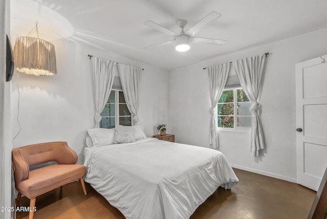 bedroom featuring ceiling fan with notable chandelier and concrete floors