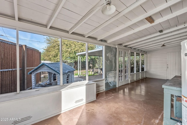 unfurnished sunroom featuring vaulted ceiling with beams