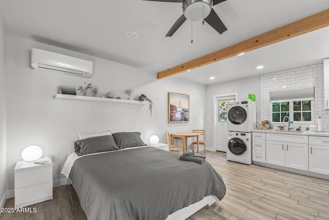 bedroom with ceiling fan, sink, beamed ceiling, an AC wall unit, and stacked washer and clothes dryer