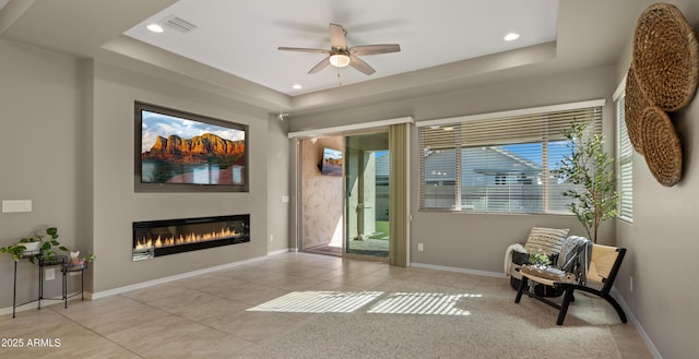 4341 E Evelyn St, Gilbert, AZ 85295 - living area featuring tile patterned floors, a glass covered fireplace, ceiling fan, a raised ceiling, and recessed lighting