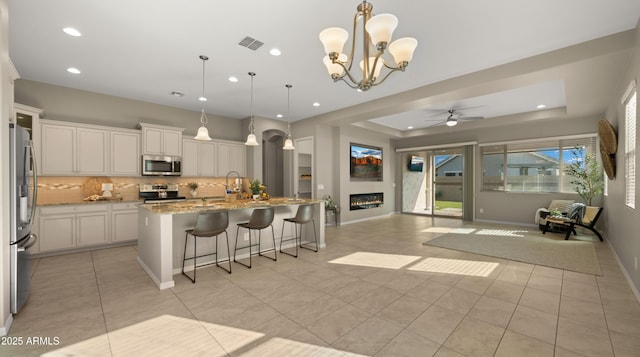 4341 E Evelyn St, Gilbert, AZ 85295 - kitchen with appliances with stainless steel finishes, open floor plan, decorative backsplash, recessed lighting, and light stone countertops
