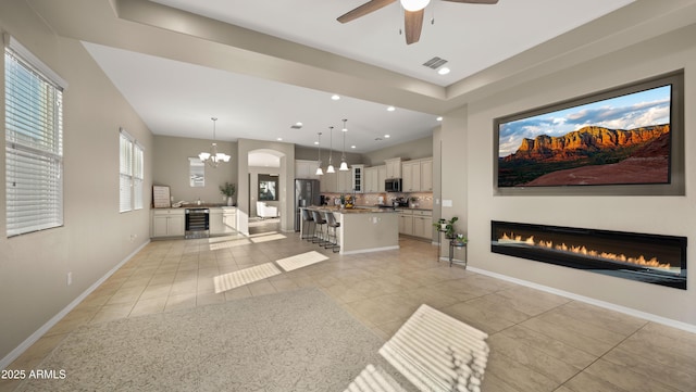 4341 E Evelyn St, Gilbert, AZ 85295 - living area with beverage cooler, light tile patterned flooring, a glass covered fireplace, ceiling fan, and a chandelier