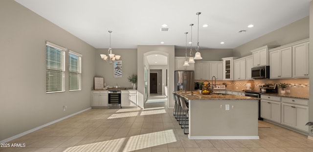 4341 E Evelyn St, Gilbert, AZ 85295 - kitchen featuring appliances with stainless steel finishes, wine cooler, backsplash, dark stone countertops, and glass insert cabinets