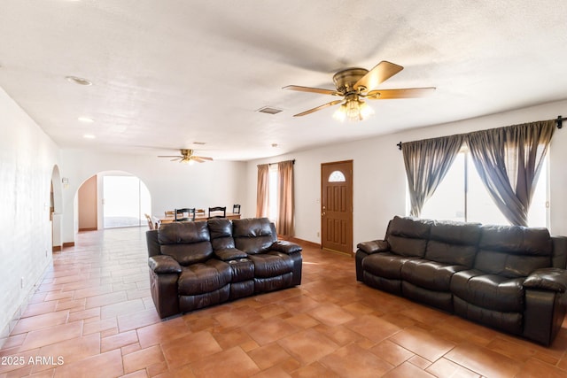 living room with ceiling fan and a textured ceiling