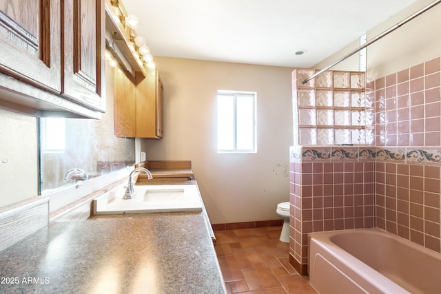 full bathroom featuring vanity, tile patterned flooring, tiled shower / bath combo, and toilet