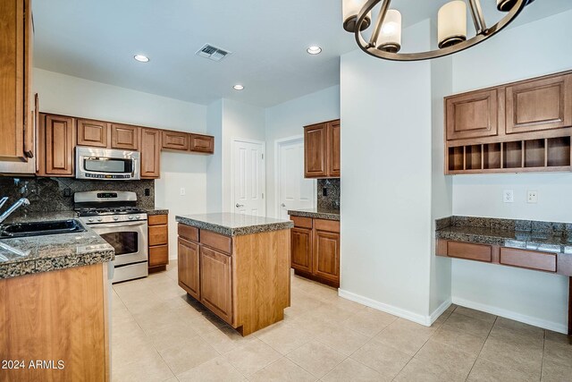 kitchen with backsplash, a center island, decorative light fixtures, stainless steel appliances, and sink