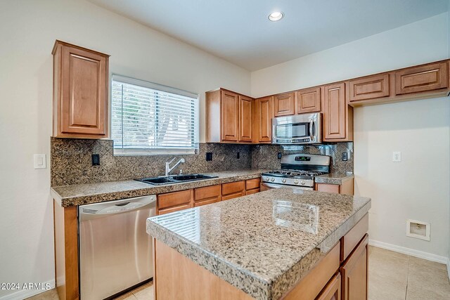 kitchen featuring a center island, sink, appliances with stainless steel finishes, and tasteful backsplash