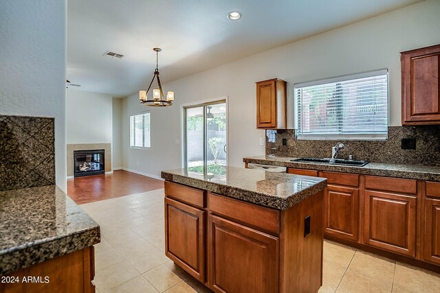 kitchen with a kitchen island, an inviting chandelier, decorative light fixtures, sink, and decorative backsplash