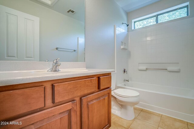 full bathroom featuring vanity, toilet, tiled shower / bath combo, and tile patterned floors