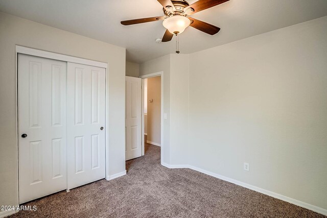 unfurnished bedroom with a closet, ceiling fan, and carpet