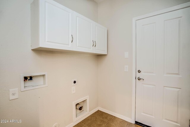 washroom featuring dark tile patterned flooring, hookup for a washing machine, cabinets, and electric dryer hookup