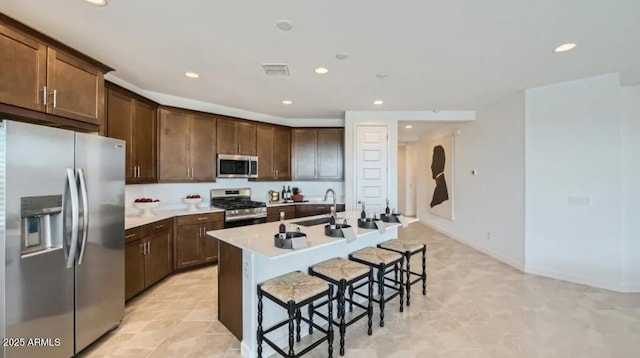 23113 E Saddle Way, Queen Creek, AZ 85142 - kitchen featuring stainless steel appliances, recessed lighting, a breakfast bar, a center island with sink, and dark brown cabinets