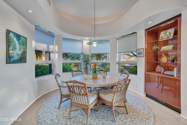 tiled dining space featuring a tray ceiling