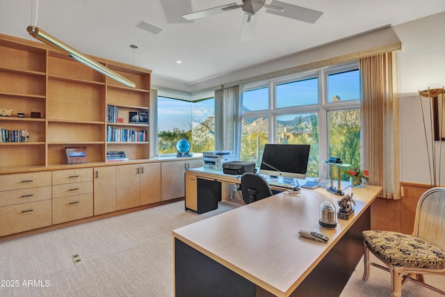 office area featuring light carpet, ceiling fan, and a healthy amount of sunlight