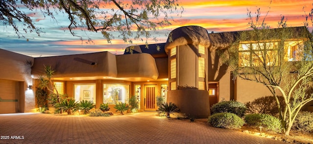 exterior entry at dusk with a garage