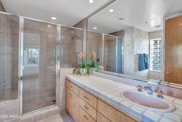 bathroom featuring vanity, a shower with shower door, and tile patterned flooring