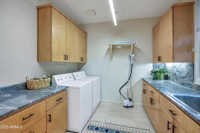 washroom featuring cabinets, separate washer and dryer, and sink