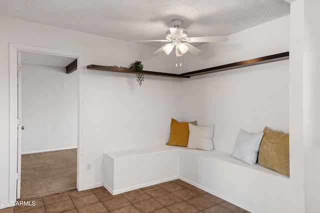 mudroom with ceiling fan, tile patterned flooring, and a textured ceiling