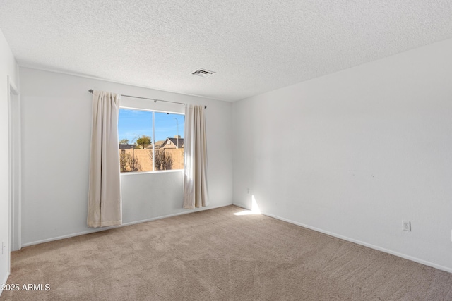 carpeted empty room featuring a textured ceiling