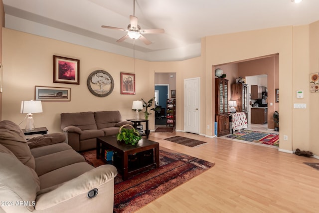 living room with ceiling fan, vaulted ceiling, and hardwood / wood-style flooring