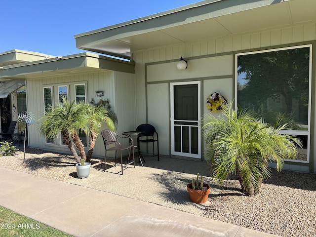 view of exterior entry with a patio area