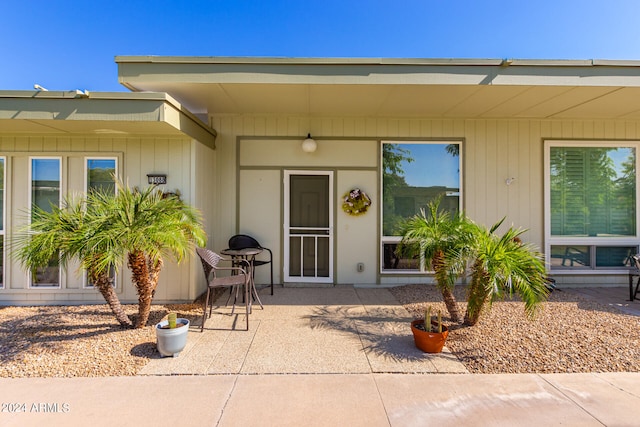 view of exterior entry with a patio