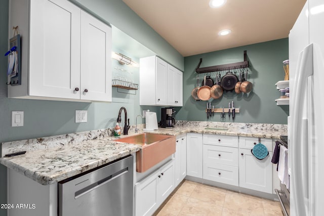 kitchen featuring white cabinets, light tile patterned floors, sink, stainless steel appliances, and light stone countertops