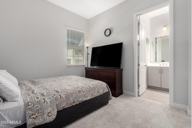 bedroom featuring light colored carpet and ensuite bathroom