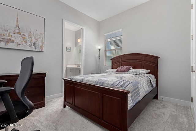 bedroom with connected bathroom and light carpet