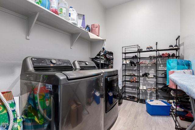 washroom with independent washer and dryer and light hardwood / wood-style floors