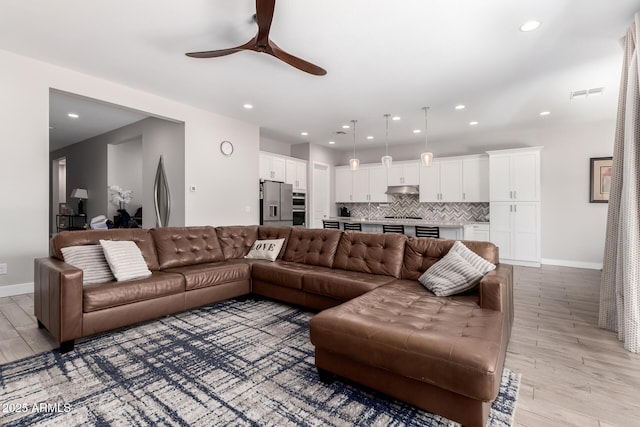 living room featuring ceiling fan and light wood-type flooring