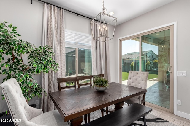 dining space with a notable chandelier and light wood-type flooring