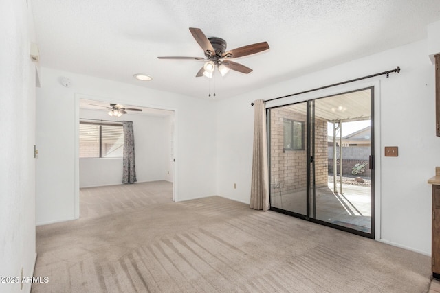 carpeted spare room featuring ceiling fan and a textured ceiling