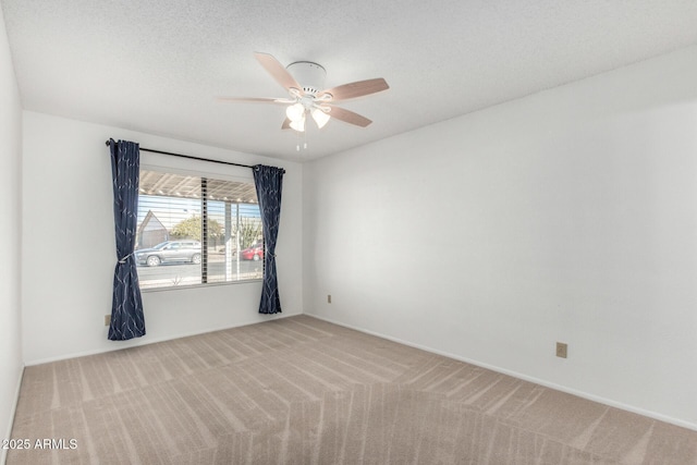 unfurnished room featuring ceiling fan, light colored carpet, and a textured ceiling